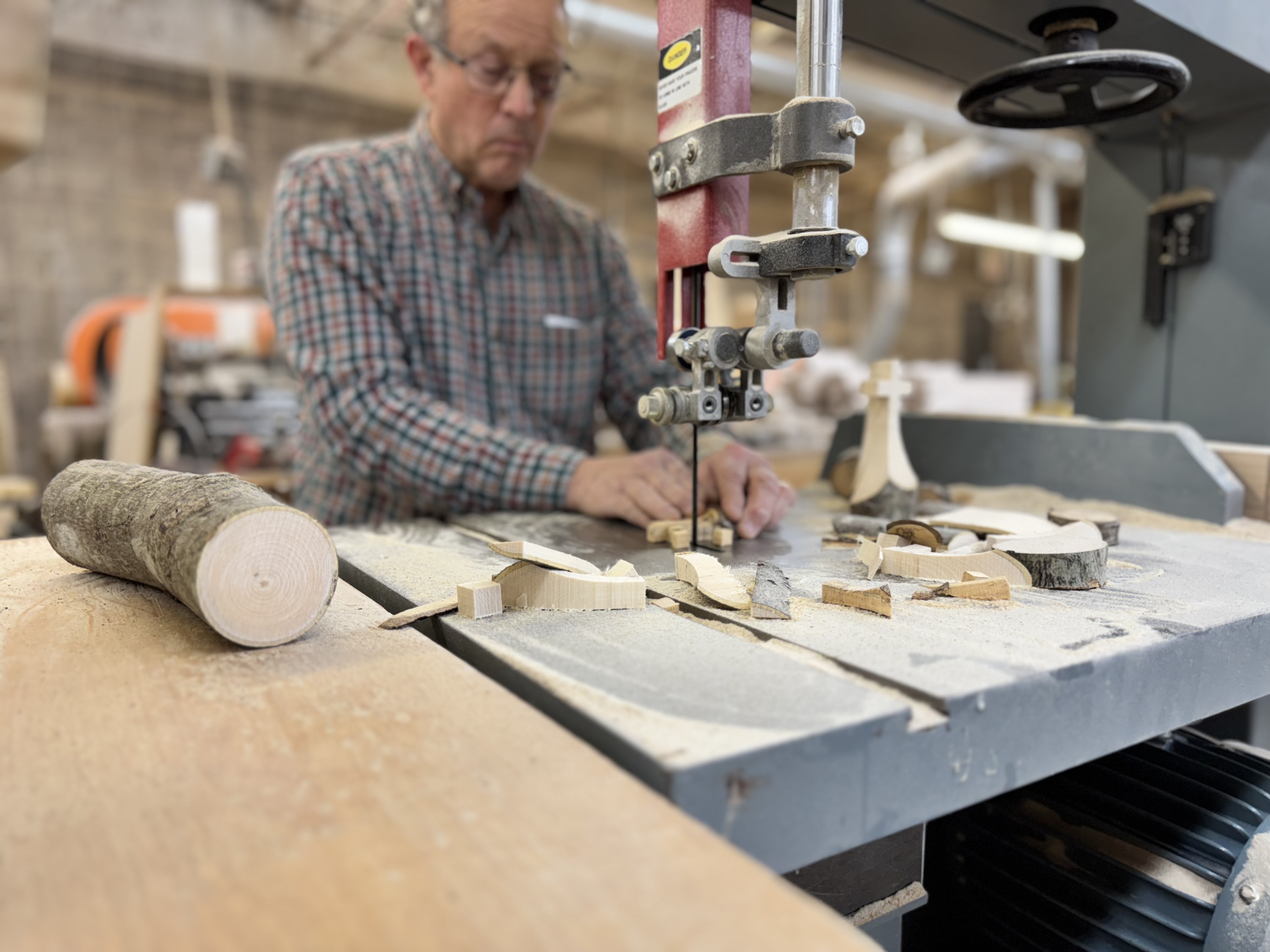 Tom Ullman at the bandsaw cutting crosses from hurricane-felled wood